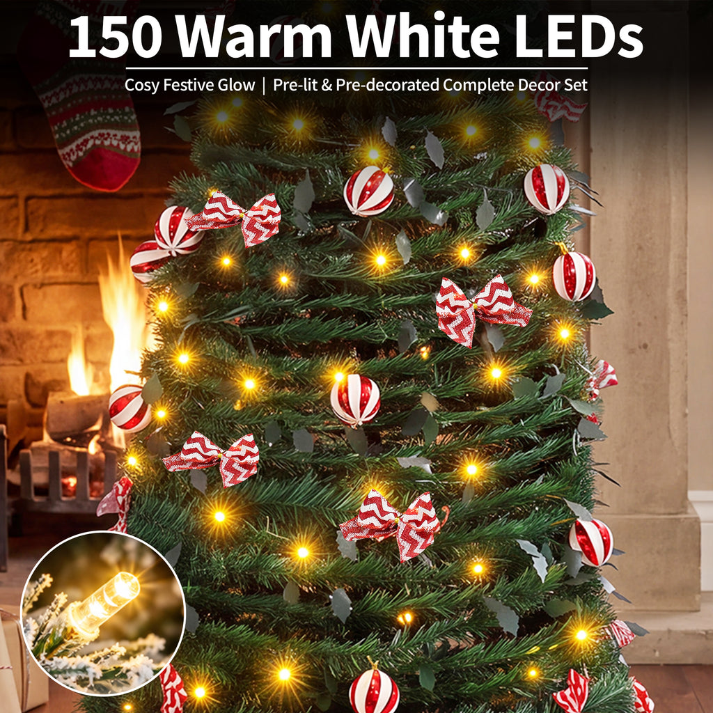 A pre-lit Christmas tree decoration set shown lit with warm white LEDs, featuring green artificial tree branches, red-and-white striped ornaments, and red-and-white striped bows, with fireplace background and text reading '150 Warm White LEDs'.