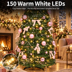 A decorated Christmas tree in a cozy living room setting, lit with 150 warm white LEDs. The tree is adorned with pink ornaments, pink ribbon bows, and white garlands.