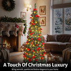 A decorated artificial Christmas tree stands in a cozy living room with a fireplace, sofa, stockings, and window view. The tree is green with warm yellow lights, red bows, and red ornaments.